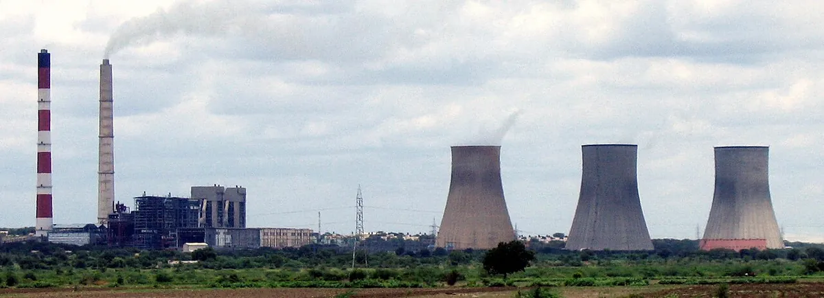 Thermal power station with cooling towers and chimneys